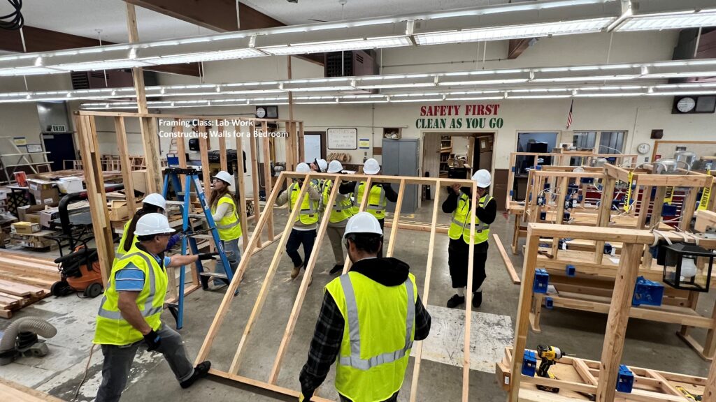 Framing and Drywall class picture of students building a bedroom wall.