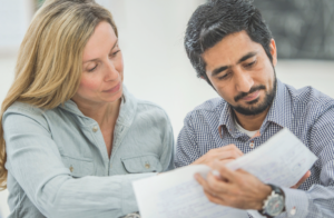 Picture of a woman teaching a man how to read.